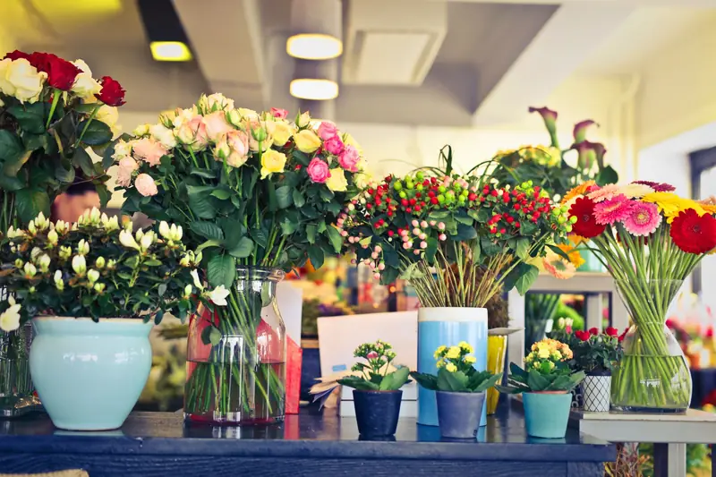 Bancone di un negozio di fiori con mazzi colorati e vasi.